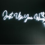 A photo of a neon sign that says Just Use Your Wings