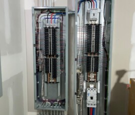 Indoor electrical panel with neatly arranged breakers and organized wiring in multiple colors.